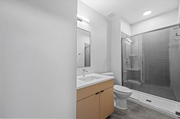 A bathroom with a toilet, sink, and shower at The Avenue Lofts Golden Apartments, Colorado